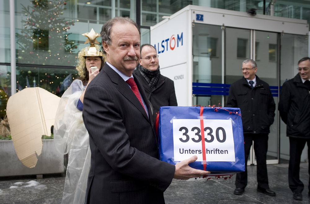 Uebergabe einer Petition mit 3330 Unterschriften an den Personalleiter von Alstom, Walter Hiltbrunner(vorn), durch Max Chopard-Acklin(mitte hinten) von der Gewerkschaft UNiA am 20.12.2010 vor dem Hauptgebäude von Alstom in Baden.