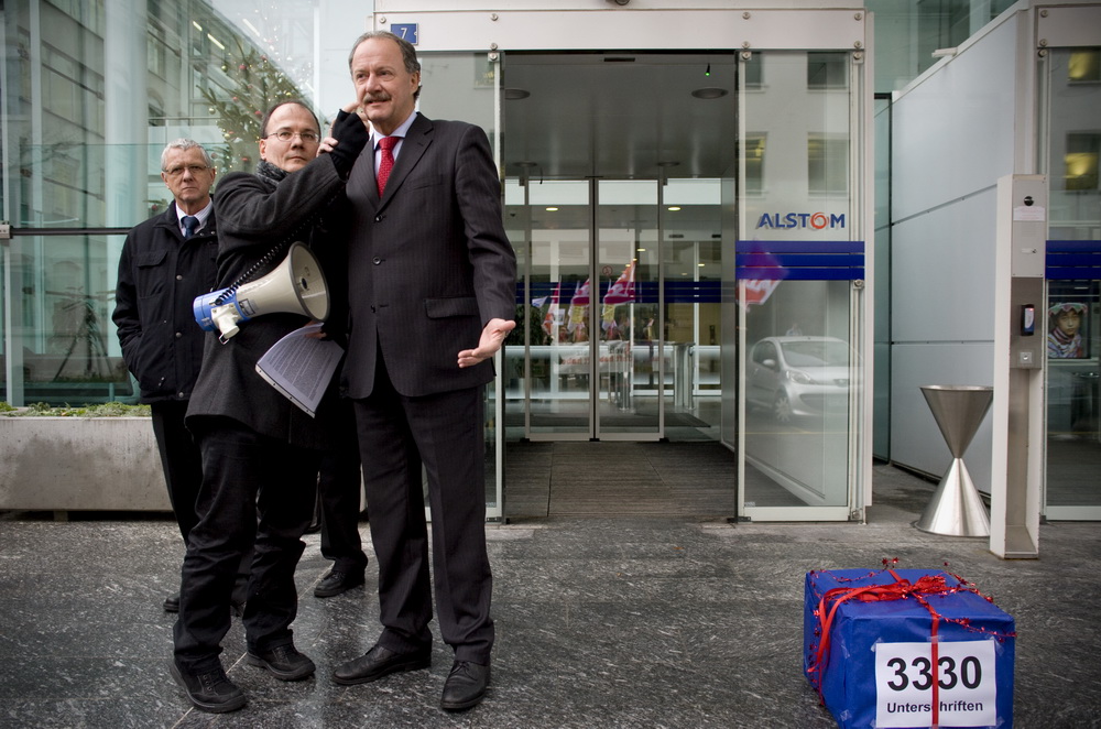 Uebergabe einer Petition mit 3330 Unterschriften an den Personalleiter von Alstom, Walter Hiltbrunner (rechts), durch Max Chopard-Acklin (mitte) von der Gewerkschaft UNiA am 20.12.2010 vor dem Hauptgebäude von Alstom in Baden.